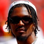 Washington Commanders quarterback Jayden Daniels (5) looks on from the sidelines during the game against the Baltimore Ravens at Northwest Stadium.