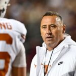 College Station, Texas, USA; Texas Longhorns head coach Steve Sarkisian speaks with quarterback Arch Manning (16) during warm ups against the Texas A&M Aggies at Kyle Field.