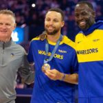 Golden State Warriors guard Stephen Curry (center) is flanked by head coach Steve Kerr and forward Draymond Green as he is presented his gold medal for his performance for Team USA at the 2024 Summer Olympics in Paris before taking on the Sacramento Kings at Chase Center.