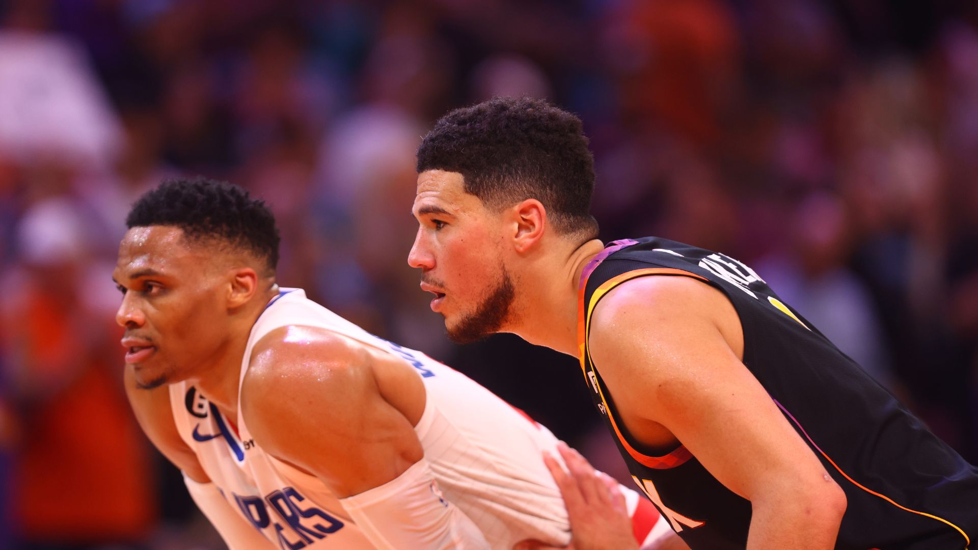 Apr 18, 2023; Phoenix, Arizona, USA; Los Angeles Clippers guard Russell Westbrook (0) against Phoenix Suns guard Devin Booker (1) during game two of the 2023 NBA playoffs at Footprint Center.