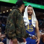 Apr 1, 2025; Memphis, Tennessee, USA; Golden State Warriors guard Stephen Curry (30) talks with guard Gary Payton II (0) during the second quarter against the Memphis Grizzlies at FedExForum.