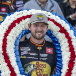 Oct 19, 2025; Talladega, Alabama, USA; NASCAR Cup Series driver Chase Briscoe (19) poses with the victory wreath with Miss Alabama Emma Terry in victory lane at the YellaWood 500 at Talladega Superspeedway. Mandatory Credit: Vasha Hunt-Imagn Images