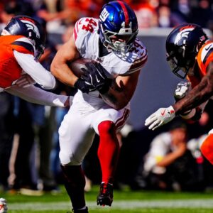 New York Giants running back Cam Skattebo (44) runs the ball against pressure from the Denver Broncos during the second half at Empower Field at Mile High.