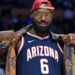 Oct 24, 2025; Los Angeles, California, USA; Los Angeles Lakers forward LeBron James poses in the Arizona Wildcats jersey of his son Bryce James (6) during the game against the Minnesota Timberwolves at Crypto.com Arena.