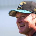 Former NFL Coach Jon Gruden have a laugh while attending an NFL training camp session ten at the Miller Electric Center, Tuesday, Aug. 5, 2025, in Jacksonville, Fla.