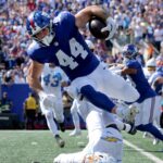 New York Giants running back Cam Skattebo (44) leaps over Los Angeles Chargers cornerback Cam Hart (20) during the second quarter at MetLife Stadium.