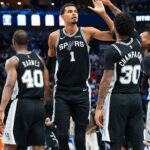 San Antonio Spurs forward Victor Wembanyama (1) celebrates with San Antonio Spurs forward Julian Champagnie (30) and San Antonio Spurs guard Stephon Castle (5) and San Antonio Spurs forward Harrison Barnes (40) during the second half against the Dallas Mavericks at American Airlines Center.