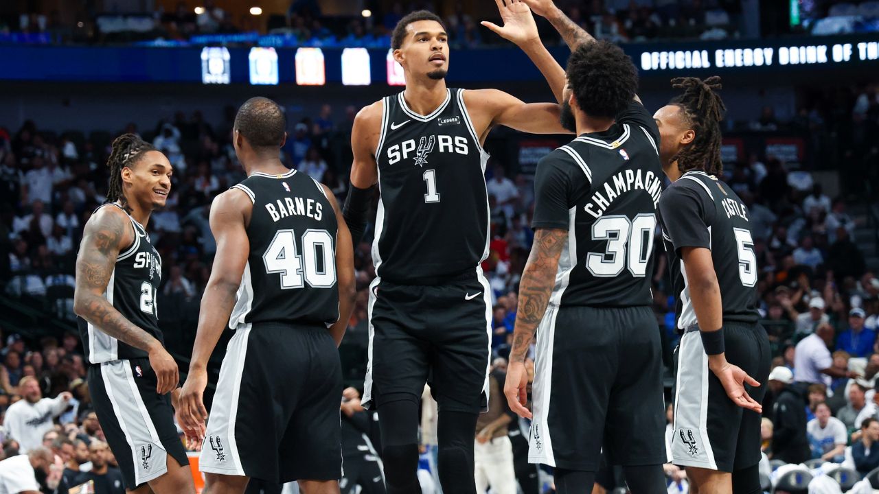 San Antonio Spurs forward Victor Wembanyama (1) celebrates with San Antonio Spurs forward Julian Champagnie (30) and San Antonio Spurs guard Stephon Castle (5) and San Antonio Spurs forward Harrison Barnes (40) during the second half against the Dallas Mavericks at American Airlines Center.