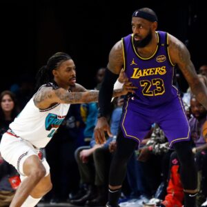 Mar 29, 2025; Memphis, Tennessee, USA; Los Angeles Lakers forward LeBron James (23) dribbles as Memphis Grizzlies guard Ja Morant (12) defends during the third quarter at FedExForum.