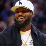 Oct 5, 2025; San Francisco, California, USA; Los Angeles Lakers forward LeBron James (23), wearing a Los Angeles Dodgers hat, watches from the sideline during a break against the Golden State Warriors in the third quarter at Chase Center.