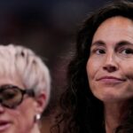 Megan Rapinoe (left) sits next to her wife, Sue Bird, on Friday, July 18, 2025, during the WNBA All-Star 3-point and skills contests at Gainbridge Fieldhouse in Indianapolis.