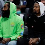 Dec 12, 2021; Detroit, Michigan, USA; Brooklyn Nets guard James Harden (left) and forward Kevin Durant (right) sit on the bench in the first half against the Detroit Pistons at Little Caesars Arena