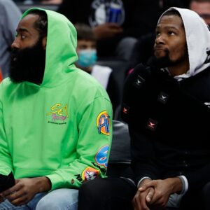 Dec 12, 2021; Detroit, Michigan, USA; Brooklyn Nets guard James Harden (left) and forward Kevin Durant (right) sit on the bench in the first half against the Detroit Pistons at Little Caesars Arena
