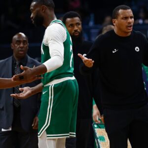 Oct 22, 2025; Boston, Massachusetts, USA; As Boston Celtics guard Jaylen Brown (7) talks with referee Michael Smith (38), head coach Joe Mazzulla gestures towards another official after Brown was called for a charge during the second half against the Philadelphia 76ers at TD Garden