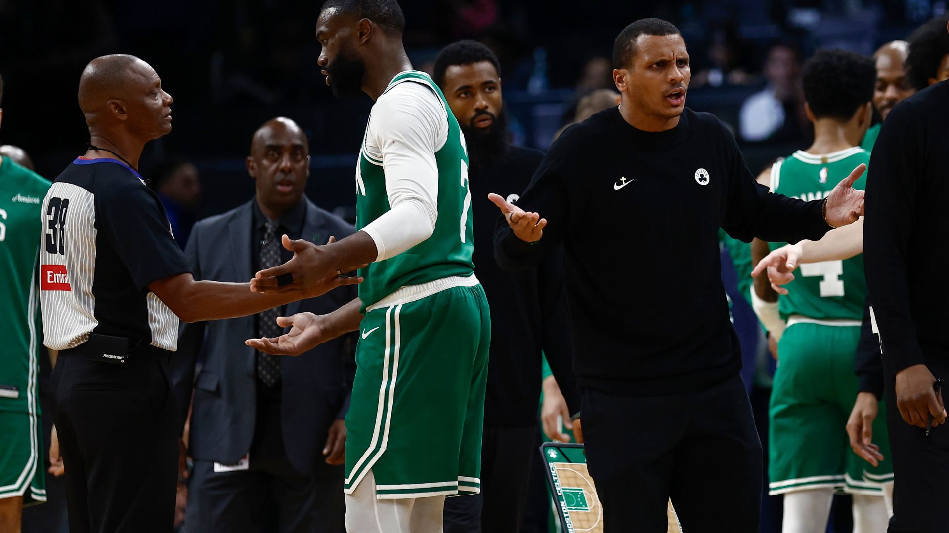 Oct 22, 2025; Boston, Massachusetts, USA; As Boston Celtics guard Jaylen Brown (7) talks with referee Michael Smith (38), head coach Joe Mazzulla gestures towards another official after Brown was called for a charge during the second half against the Philadelphia 76ers at TD Garden
