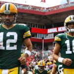 Green Bay Packers quarterbacks Aaron Rodgers (12) and Jordan Love (10) run out onto the field against the Tampa Bay Buccaneers at Raymond James Stadium.