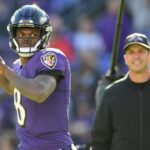 Baltimore Ravens quarterback Lamar Jackson (8) passes as head coach John Harbaugh looks prior to the game against the Los Angeles Chargers in a AFC Wild Card playoff football game at M&T Bank Stadium.