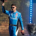 Nov 2, 2025; Avondale, Arizona, USA; NASCAR Cup Series driver Denny Hamlin walks by the championship trophy as he introduced prior to the NASCAR Championship race at Phoenix Raceway.