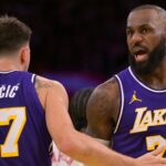 Nov 25, 2025; Los Angeles, California, USA; Los Angeles Lakers guard Luka Doncic (77) and forward LeBron James (23) react after a foul during the first half against the Los Angeles Clippers at Crypto.com Arena