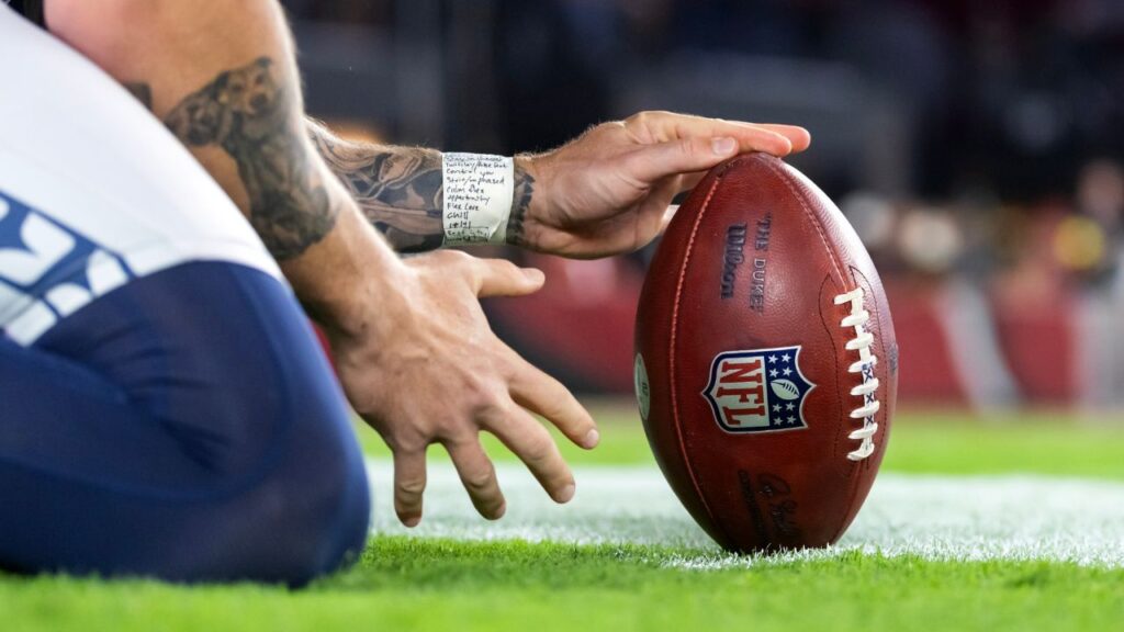 Detailed view as a Seattle Seahawks kick holder positions the official Wilson NFL football with laces out against the Arizona Cardinals at State Farm Stadium.