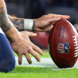 Detailed view as a Seattle Seahawks kick holder positions the official Wilson NFL football with laces out against the Arizona Cardinals at State Farm Stadium.
