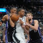 San Antonio Spurs forward Keldon Johnson (3) grabs a rebound in between Sacramento Kings guard Russell Westbrook (18) and forward Domantas Sabonis (11) in the second half at Frost Bank Center.