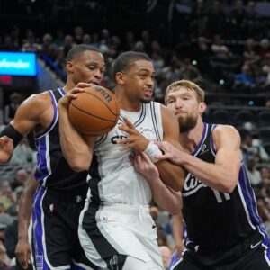 San Antonio Spurs forward Keldon Johnson (3) grabs a rebound in between Sacramento Kings guard Russell Westbrook (18) and forward Domantas Sabonis (11) in the second half at Frost Bank Center.