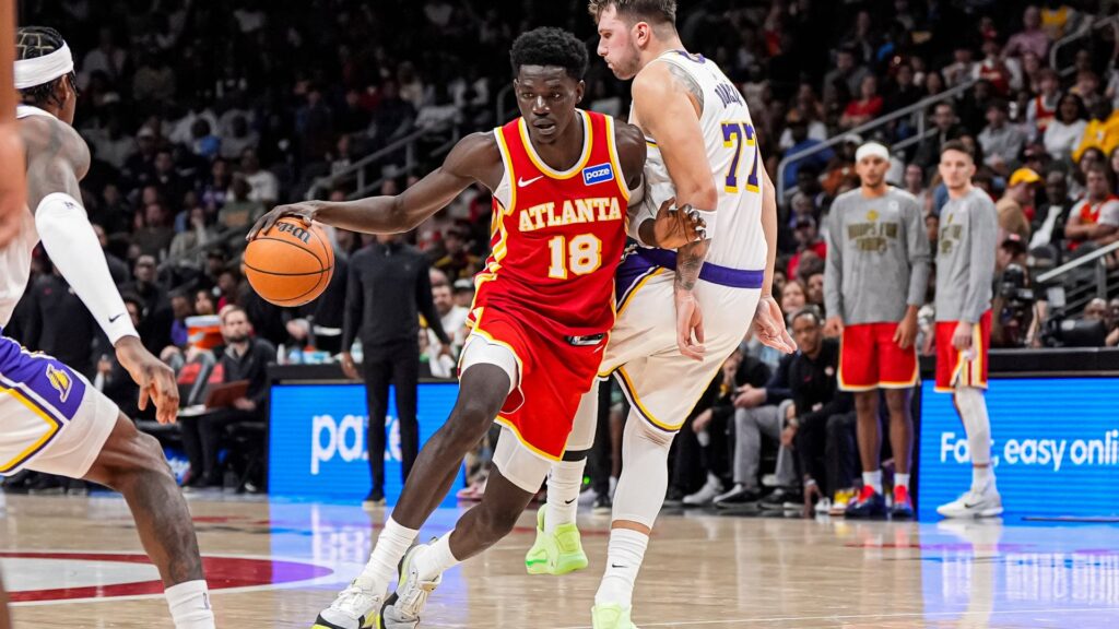 Nov 8, 2025; Atlanta, Georgia, USA; Atlanta Hawks forward Mouhamed Gueye (18) dribbles against Los Angeles Lakers guard Luka Doncic (77) during the second half at State Farm Arena.