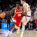Nov 8, 2025; Atlanta, Georgia, USA; Atlanta Hawks forward Mouhamed Gueye (18) dribbles against Los Angeles Lakers guard Luka Doncic (77) during the second half at State Farm Arena.