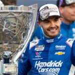 Nov 2, 2025; Avondale, Arizona, USA; NASCAR Cup Series driver Kyle Larson (5) celebrates with the Bill France Cup trophy after clinching the 2025 NASCAR Cup Series Championship following the NASCAR Championship race at Phoenix Raceway.