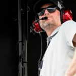 Dale Earnhardt Jr. looks out from his pit box Saturday, July 26, 2025, during the Pennzoil 250 at Indianapolis Motor Speedway.