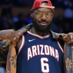 Oct 24, 2025; Los Angeles, California, USA; Los Angeles Lakers forward LeBron James poses in the Arizona Wildcats jersey of his son Bryce James (6) during the game against the Minnesota Timberwolves at Crypto.com Arena.