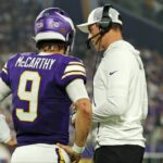 Minnesota Vikings quarterback J.J. McCarthy (9) speaks with Minnesota Vikings head coach Kevin O'Connell during the first half against the Atlanta Falcons at U.S. Bank Stadium.