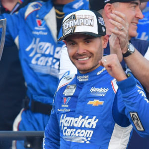 Nov 2, 2025; Avondale, Arizona, USA; NASCAR Cup Series driver Kyle Larson (5) celebrates his championship victory following the Cup Series Championship race with son Owen at Phoenix Raceway. Mandatory Credit: Gary A. Vasquez-Imagn Images