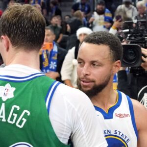 Golden State Warriors guard Stephen Curry (30) and Dallas Mavericks forward Cooper Flagg (center left) greet each other after the game at Chase Center.