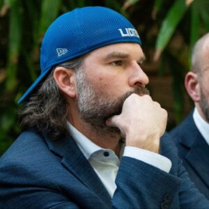 Detroit Lions fan Ryan Kennedy, center, listens during a press conference while being represented by Head Murphy Law attorney Sean Murphy, left, and Head Murphy Law founder and Managing Member Shawn Head,right, during a press conference at Head Murphy Law in Farmington Hills on Friday, December 26, 2025, while discussing the fan involved in an altercation with Pittsburgh Steelers player DK Metcalf at the Detroit Lions game at Ford Field last Sunday.