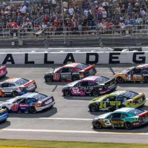 Oct 19, 2025; Talladega, Alabama, USA; Cars race by Talladega signage during stage one of the YellaWood 500 at Talladega Superspeedway