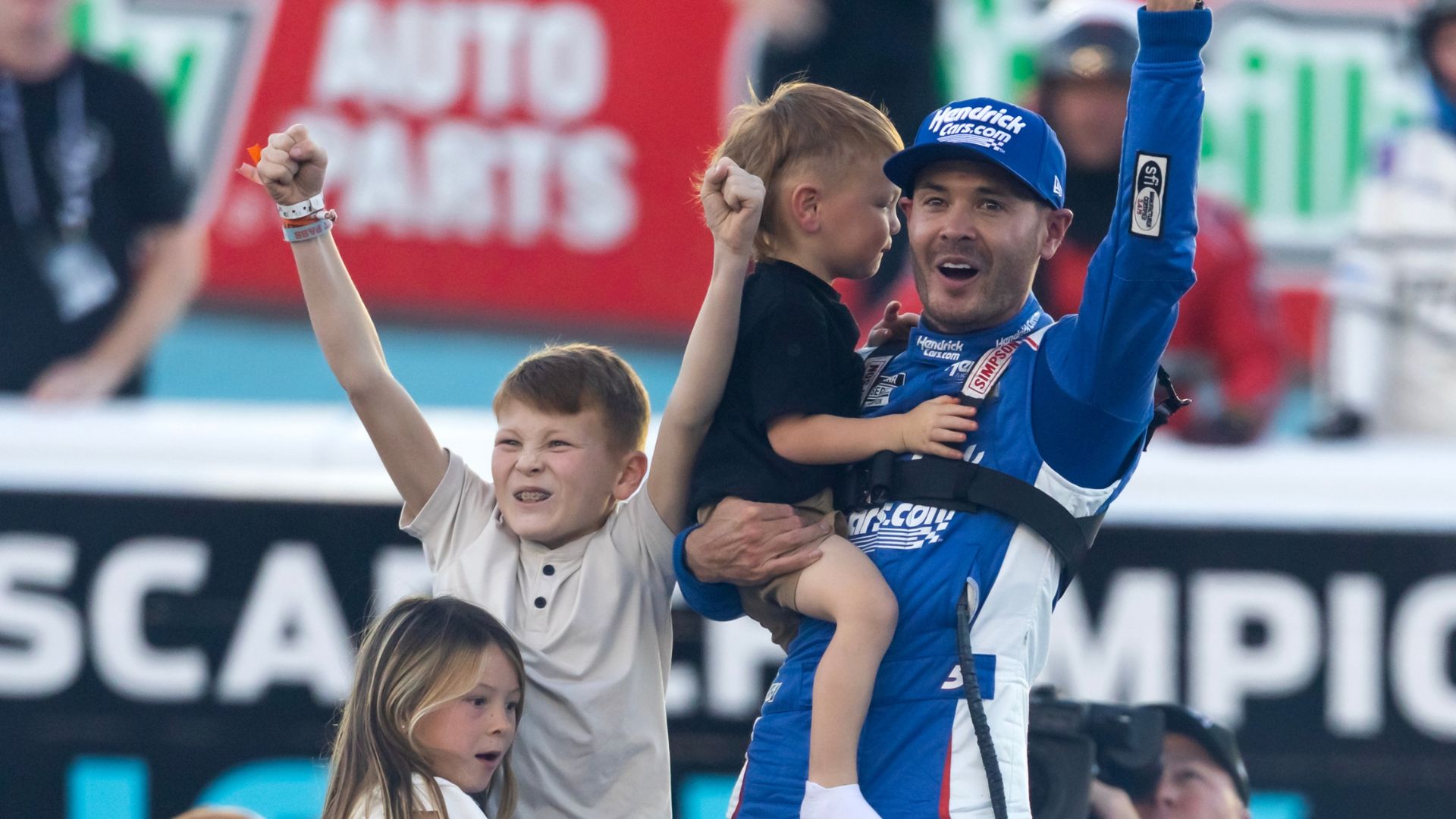 Nov 2, 2025; Avondale, Arizona, USA; NASCAR Cup Series driver Kyle Larson (5) celebrates with children Owen Larson, Audrey Larson and Cooper Larson after clinching the 2025 NASCAR Cup Series Championship following the NASCAR Championship race at Phoenix Raceway
