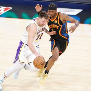 Los Angeles Lakers guard Luka Doncic (77) drives down the court beside Oklahoma City Thunder guard Shai Gilgeous-Alexander (2) during the second half at Paycom Center.