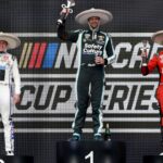 Shane Van Gisbergen celebrates on the podium after winning the NASCAR Cup Series Mexico alongside second place driver Christopher Bell and third place driver Chase Elliott during the NASCAR Cup Series Mexico City Race at Autodromo Hermanos Rodriguez.