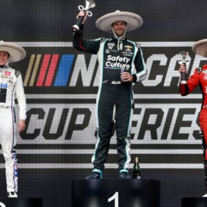 Shane Van Gisbergen celebrates on the podium after winning the NASCAR Cup Series Mexico alongside second place driver Christopher Bell and third place driver Chase Elliott during the NASCAR Cup Series Mexico City Race at Autodromo Hermanos Rodriguez.
