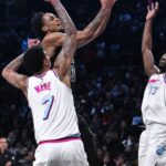 Brooklyn Nets center Nic Claxton (33) drives to the basket against Miami Heat center Kel'el Ware (7) and center Bam Adebayo (13) during the second half at Barclays Center