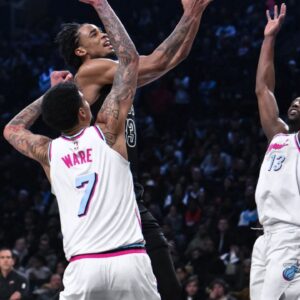 Brooklyn Nets center Nic Claxton (33) drives to the basket against Miami Heat center Kel'el Ware (7) and center Bam Adebayo (13) during the second half at Barclays Center