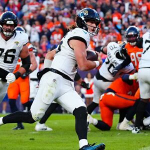 Jacksonville Jaguars quarterback Trevor Lawrence (16) rushes for a touchdown against the Denver Broncos during the second half at Empower Field at Mile High.