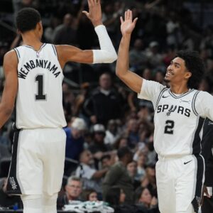 Oct 26, 2025; San Antonio, Texas, USA; San Antonio Spurs forward Victor Wembanyama (1) and guard Dylan Harper (2) celebrates in the second half against the Brooklyn Nets at Frost Bank Center.