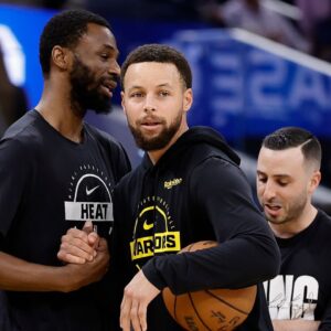 Miami Heat forward Andrew Wiggins (22) and Golden State Warriors guard Stephen Curry (30) greet each other before the game at Chase Center.