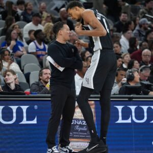 Dec 31, 2025; San Antonio, Texas, USA; San Antonio Spurs head coach Mitch Johnson talks with forward Victor Wembanyama (1) in the second half against the New York Knicks at Frost Bank Center