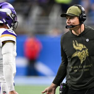 Minnesota Vikings head coach Kevin O'Connell greets quarterback J.J. McCarthy (9) after throwing a touchdown pass in the first quarter at Ford Field.