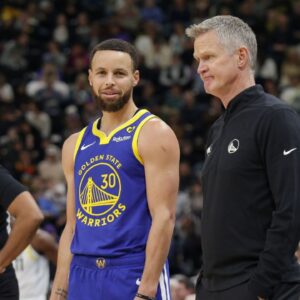 Golden State Warriors guard Stephen Curry (30) and head coach Steve Kerr talk on the sideline during the first quarter against the Utah Jazz at Delta Center.