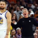 Dec 18, 2025; Phoenix, Arizona, USA; Golden State Warriors guard Stephen Curry (30) reacts alongside head coach Steve Kerr against the Phoenix Suns in the second half at Mortgage Matchup Center.
